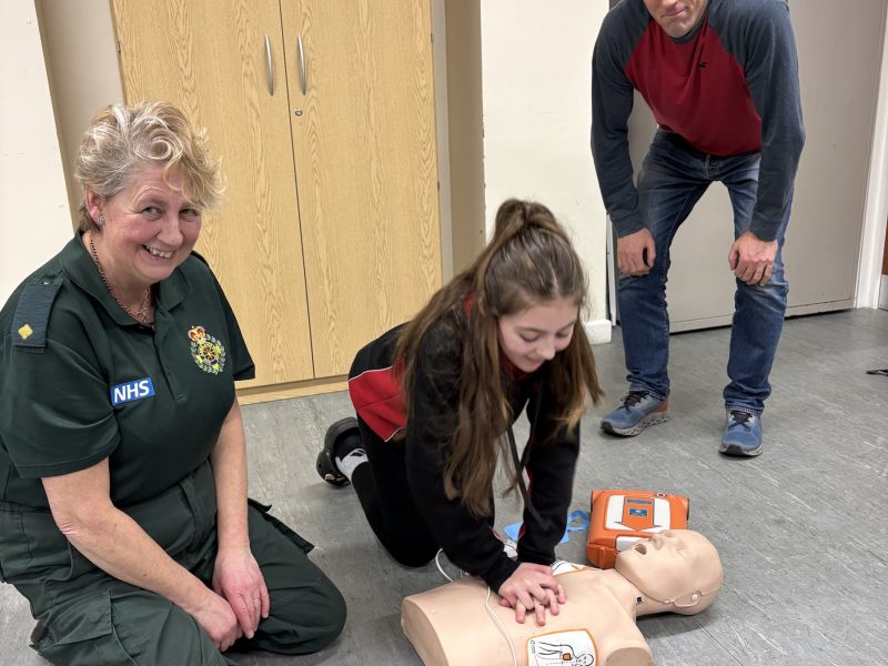 Cllr Ben Milsom and his daughter learning CPR from Sharon Kirwan