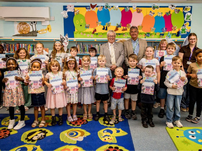 Council chair Cllr Adrian Rush and cabinet member Cllr John Bradbury with children at Hanham Library